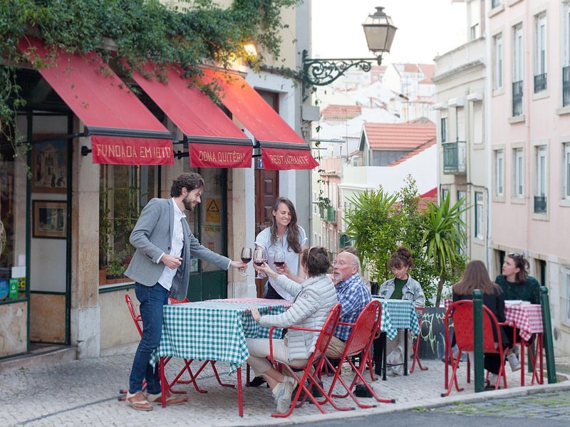 Red café tables set out on a Lisbon side street